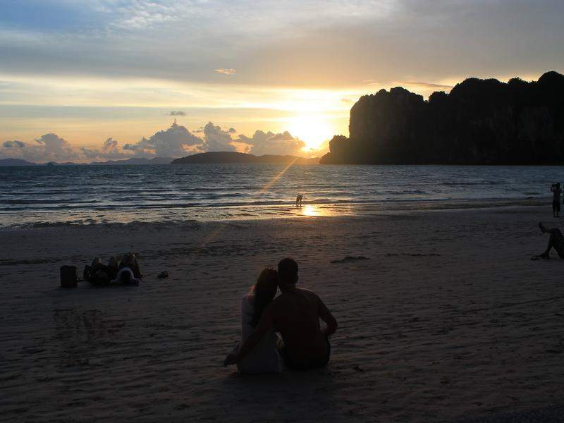 Pôr do sol em Railay todos se sentam na areia a apreciar